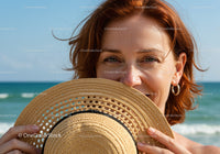 Smiling Woman with Red Hair Holding Straw Sunhat at the Beach