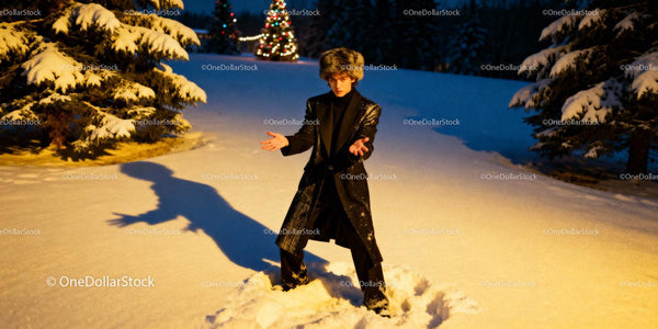 Man in Fur Hat and Black Coat in Snowy Winter Evening