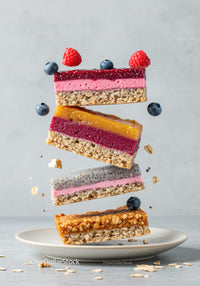 Stack of colorful layered fruit and nut bars with berries