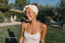 Joyful Woman Smiling Outdoors with Head Wrap and Jewelry in Summer Scene