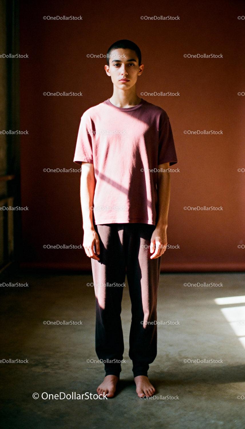 Young man standing barefoot in warm natural light
