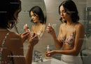 Young Woman Applying Skincare Routine in Bathroom Mirror