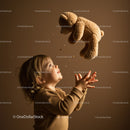 Toddler joyfully catching teddy bear indoors