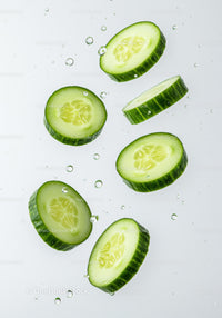 Fresh cucumber slices immersed in clear water droplets