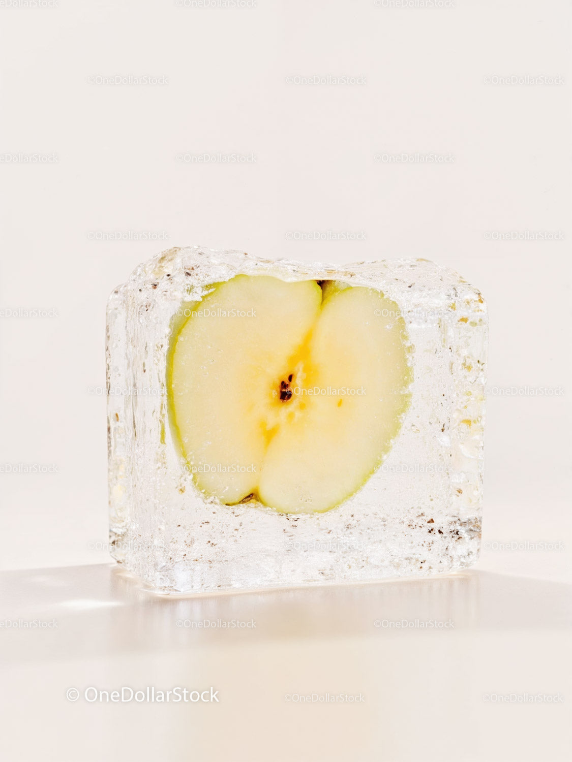 Fresh apple slice preserved inside clear ice cube