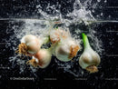Fresh Garlic Bulbs Falling into Water in a Dynamic Splash Scene