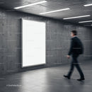 Businessman walking past blank illuminated advertising board