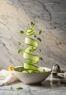 Fresh cucumber ribbons with mint drops in ceramic bowl