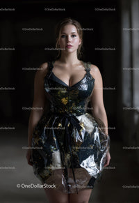 Elegant Woman in Glossy Black Floral Dress Standing against Dark Background