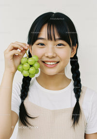 Smiling Young Girl Holding Green Grapes with Bright Natural Light