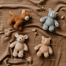 Four Plush Animal Toys on Textured Brown Fabric