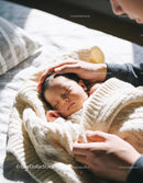Tender moment with sleeping baby wrapped in cozy blanket