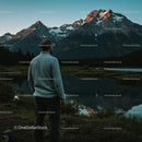 Adventurous Man Enjoying Scenic Mountain Reflection at Sunset