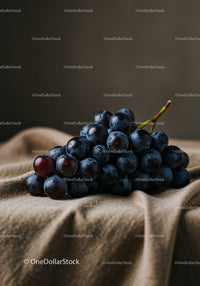 Fresh dark grapes on soft fabric background