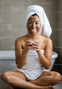 Woman with Facial Mask Smiling in Bathroom During Skincare Routine