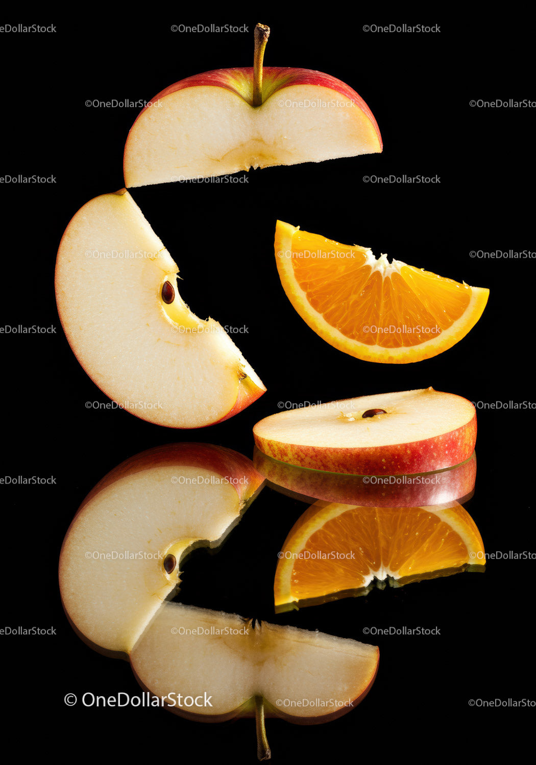 Sliced apple and orange segments on reflective surface