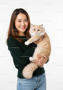 Smiling woman holding fluffy beige cat indoors