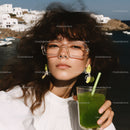 Young Woman Relaxing with Green Cocktail in Seaside Background