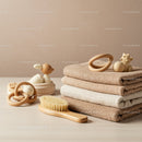 Soft neutral folded towels with natural baby brush and toys