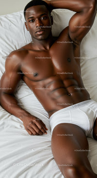 Athletic man relaxing on bed in white underwear
