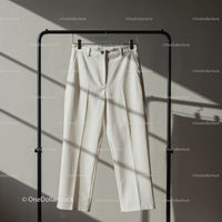 Minimalist white trousers hanging on black rack