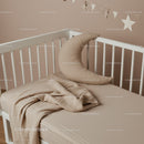 Minimalist baby crib with soft moon pillow and blanket