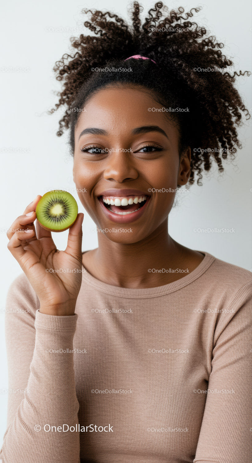 Radosna kobieta trzymająca kiwi z promiennym uśmiechem i naturalną aurą