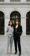 Two Stylish Women in Business Suits Standing on City Street
