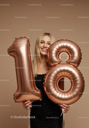 Smiling young woman celebrating 18th birthday with balloons