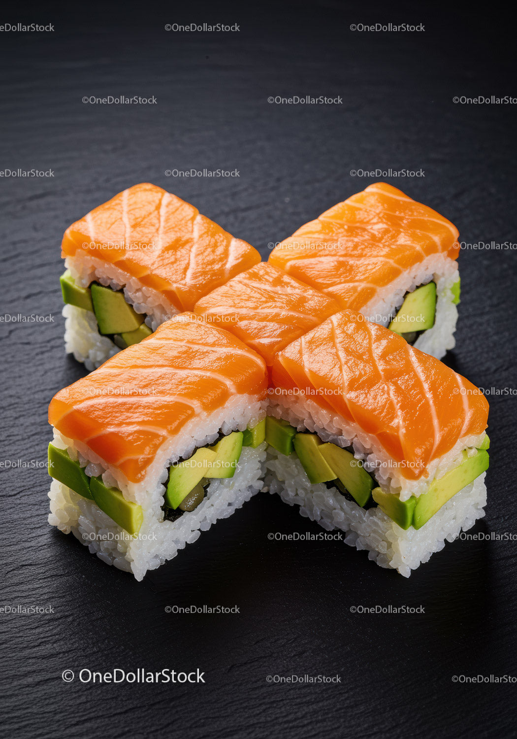 Rolki sushi z łososiem i awokado na czarnym talerzu łupkowym
