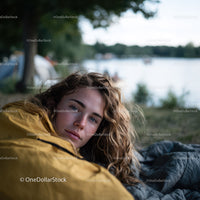 Young Woman Relaxing by the Lakeside in Yellow Jacket