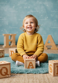 Toddler playing with wooden alphabet blocks indoors