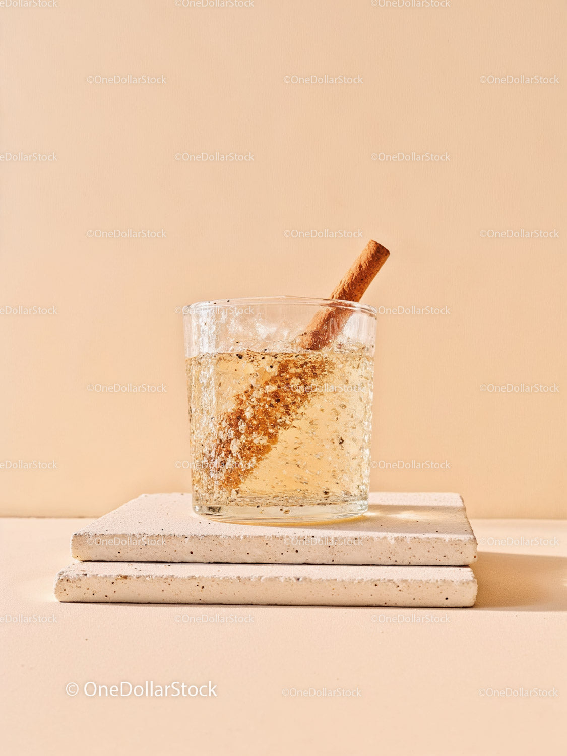 Refreshing sparkling drink with cinnamon stick on stone coasters
