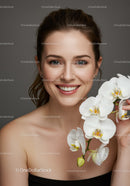 Elegant Woman with White Orchids and Joyful Expression for Beauty Concept