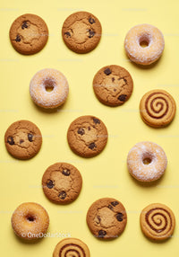 Assorted cookies and donuts on pastel yellow background