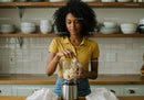 Young Woman Making Banana Smoothie in Modern Kitchen