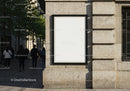 Blank poster on city stone wall with pedestrians walking