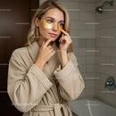 Young Woman Applying Under-Eye Gel Patches in Spa Setting