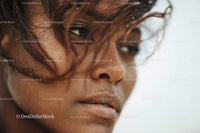 Close-up of a Woman with Wet Skin and Dark Curly Hair by the Ocean