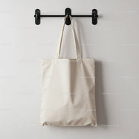 Simple cotton tote bag hanging on black wall hook
