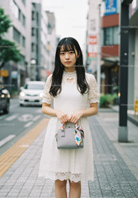 Young Woman in White Lace Dress Standing on City Street