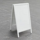 Blank white sandwich board on urban concrete pavement