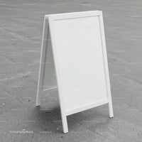 Blank white sandwich board on urban concrete pavement