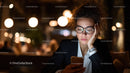 Stylish Woman Using Smartphone in Nighttime Urban Cafe