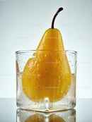 Fresh yellow pear immersed in sparkling water glass