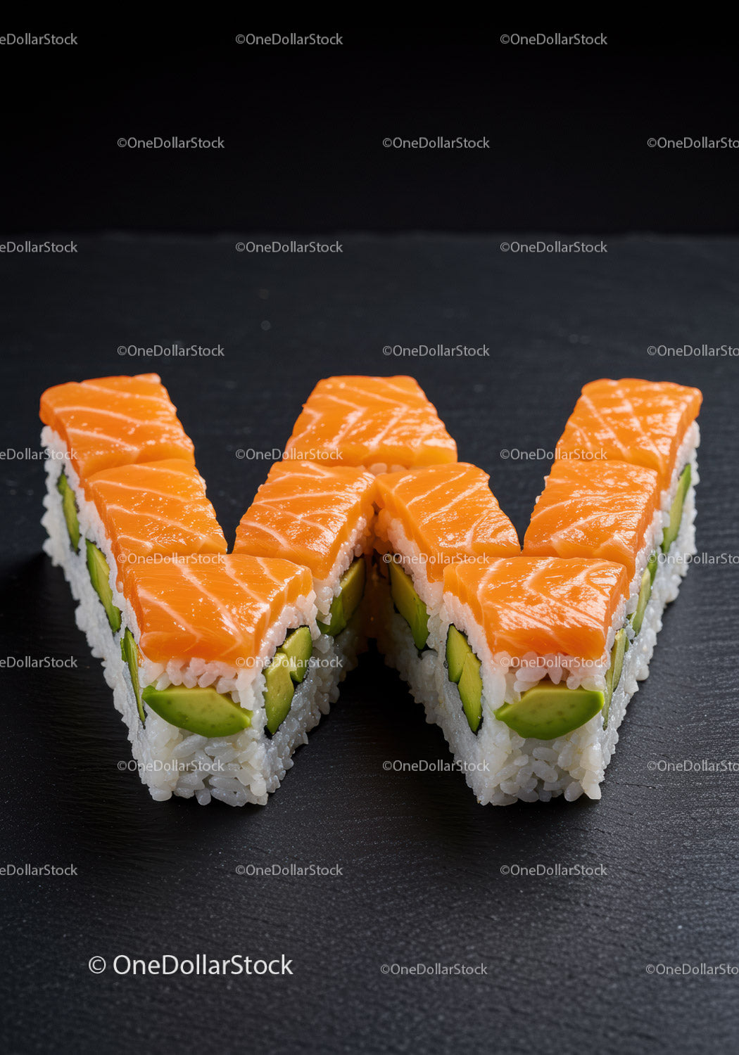 Sushi z łososiem i awokado w kształcie litery W na ciemnym łupku