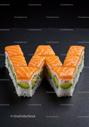 Salmon and avocado sushi shaped as letter W on dark slate