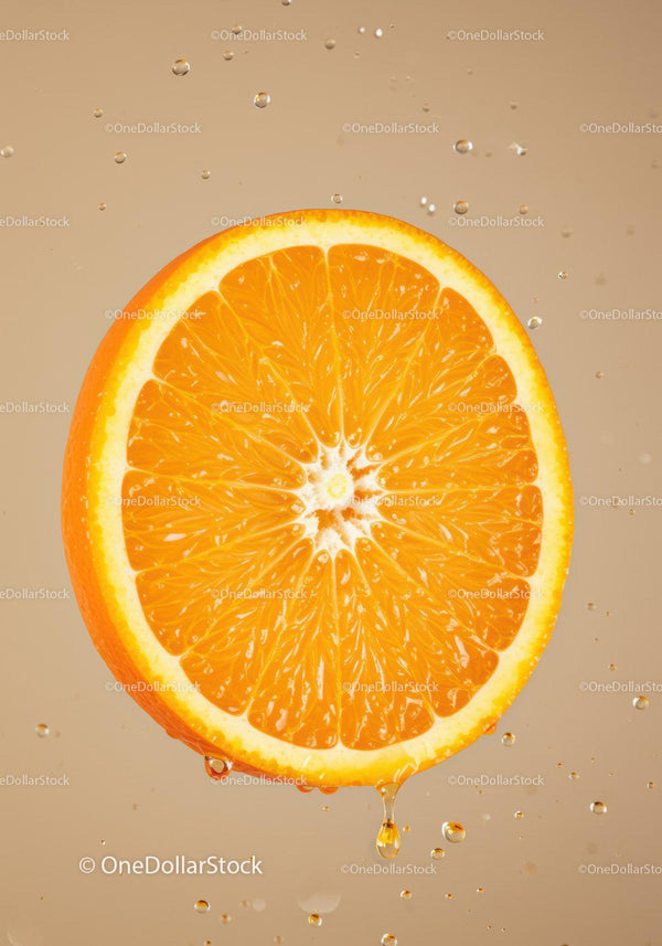 Fresh orange slice dripping juice with water droplets