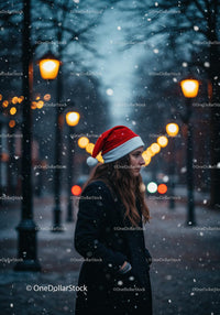 Young woman in Santa hat walking through snowy streetlights