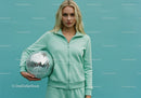 Young Woman in Mint Green Tracksuit Holding Disco Ball in Studio